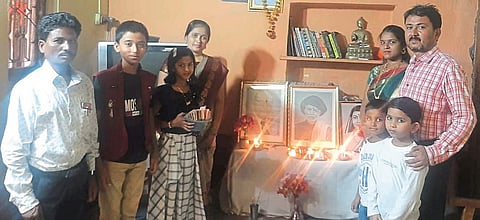 मुरूम (ता. उमरगा) : महात्मा फुले, डॉ. बाबासाहेब आंबेडकर, सावित्रीबाई फुले यांच्या प्रतिमेचे पूजन करून अभिवादन करताना प्रा. आण्णाराव कांबळे व त्यांचे कुटुंबीय.