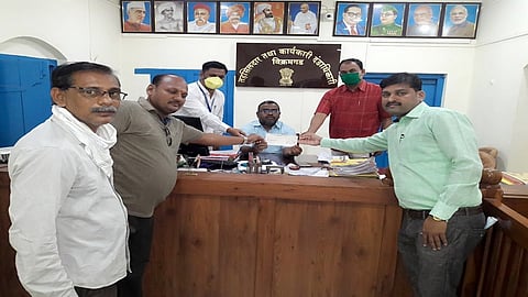 विक्रमगड ः मुख्यमंत्री साहायता निधीसाठी ११ हजार रुपयांचा धनादेश तहसीलदार श्रीधर गालीपेल्ली यांना देताना विनायक शैक्षणिक व सामाजिक संस्थेचे अध्यक्ष रुपेश विनायक पडवळे. (छायाचित्र ः अमोल सांबरे)