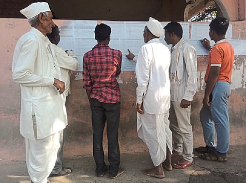 नायगाव (ता. कळंब) : कर्जमाफीच्या यादीत नाव असल्याची खात्री करताना शेतकरी.