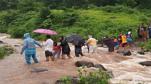 पर्यटकांना सुरक्षितपणे बाहेर काढले जात असताना आदिवासी तरुण.