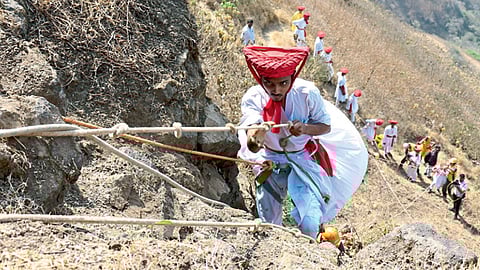 सिंहगड : दोराच्या साह्याने कड्यावरून गडावर चढताना युवक.