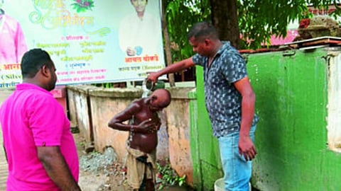 पवनी : मनोरुग्ण व्यक्तीची अंघोळ घालताना मयूर रेवतकर, मंगेश भोयर.