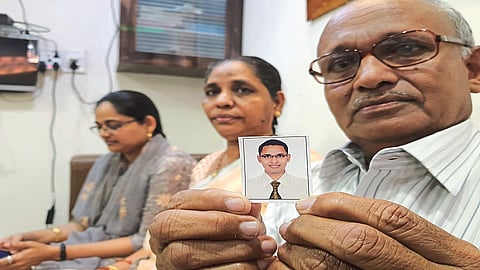 बेपत्ता इरफानचा फोटो दाखवताना पालक.