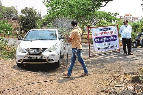 लॉकडाऊनमध्ये अत्यावश्यक सेवा देणाऱ्या वाहनांवर औषधींची फवारणी करून त्याचे निर्जंतुकीकरण करताना पालिकेचे कर्मचारी.