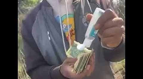 Cleaning Money With Hand Sanitizer.jpeg