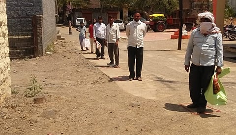 सुरक्षित अंतर ठेवून उभे असलेले ग्राहक