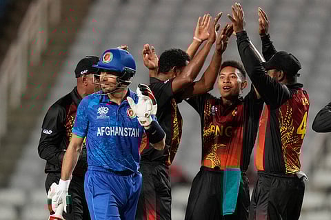 Afghanistan's batsman Rahmanullah Gurbaz leaves the field bowled by Papua New Guinea's blower Alei Nao