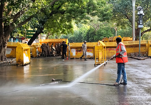An NDMC worker washes the road during a cleanliness drive at the protest site of Jantar Mantar, in New Delhi | File image/PTI