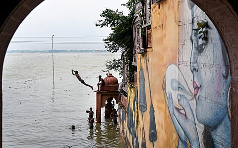 Boys dive into the swollen Ganga river from the inundated banks near Nagvasuki Temple, in Prayagraj, Uttar Pradesh | PTI