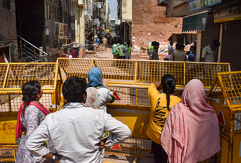 People gather at the site during a rescue operation following the collapse of a multi-storey building housing a PG accommodation at Satya Niketan, in New Delhi, on Tuesday | PTI