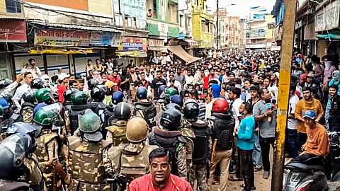 Security personnel interact with people following stone-pelting incidents during protests against the proposed removal of a portion of the 'Shahi Masjid' for road widening, in Ujjain, on Monday | PTI