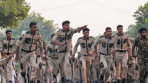 Security personnel run towards demonstrators to disperse them during a protest organised by the Cockroach Janta Party, in New Delhi, on Saturday | PTI
