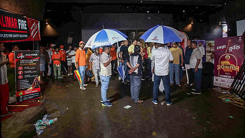 Volunteers and people gather outside the Durga Puja pandal following a stampede-like situation after an exit gate collapsed due to heavy crowd pressure, in Kolkata, on Saturday | PTI
