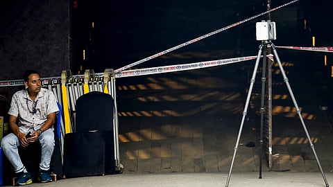A man sits near an area cordoned off amid investigation after the October 17 stampede at the Chorbagan Durga Puja pandal, in Kolkata, on Thursday | PTI
