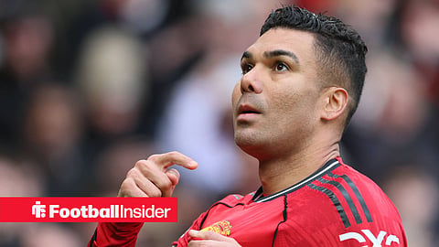 Casemiro in a Manchester United kit pointing to the badge