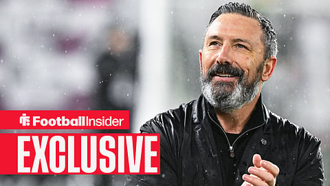 Derek McInnes clapping in rain inside stadium