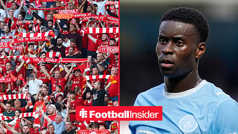 Liverpool fans in the stands at Anfield, with Marc Guehi in action for Man City