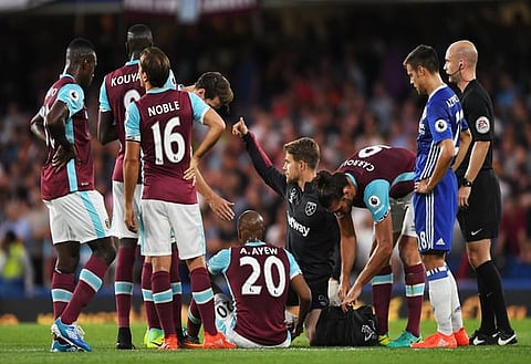 Britain Football Soccer - Chelsea v West Ham United - Premier League - Stamford Bridge - 15/8/16
West Ham United's Andre Ayew receives medical attention before going off injured
Action Images via Reuters / Tony O'Brien
Livepic
EDITORIAL USE ONLY. No use with unauthorized audio, video, data, fixture lists, club/league logos or "live" services. Online in-match use limited to 45 images, no video emulation. No use in betting, games or single club/league/player publications. Please contact your account representative for further details.