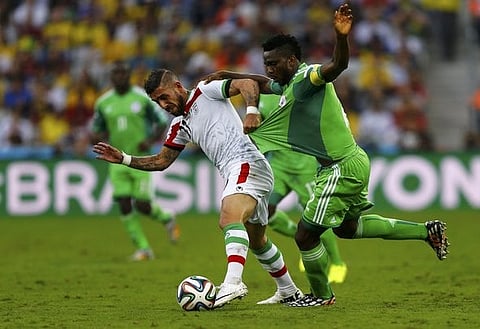 Iran's Ashkan Dejagah fights for the ball with Nigeria's Joseph Yobo during their 2014 World Cup Group F soccer match at the Baixada arena in Curitiba June 16, 2014. REUTERS/Ivan Alvarado (BRAZIL - Tags: SOCCER SPORT WORLD CUP) TOPCUP