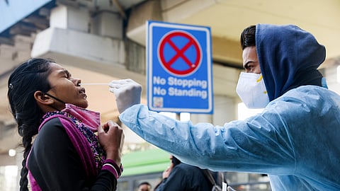 A healthcare worker collects a nasal swab sample for the COVID-19 testing,