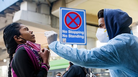 A healthcare worker collects a nasal swab sample for the COVID-19 testing.