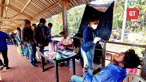 A health worker collects a swab sample from a person to test for the Covid-19 coronavirus at Margao Railway Station 