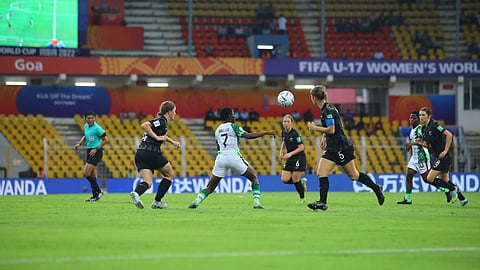 The Nigerian and New Zealand players fight for the ball.
