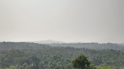 Lush green mountains in Sanguem on a foggy morning.