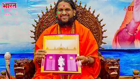 Sadguru Brahmeshanand Acharya Swami strikes a pose with the  invitation for the inauguration of the Ram Temple in Ayodhya on January 22.