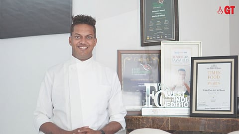 GRINS & GASTRONOMY: Chef Jason poses in front of the awards he has received for White Plate by Chef Jason.