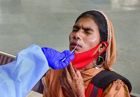 A BMC health worker collects swab samples of a passenger for COVID-19 testing at CSMT railway Station in Mumbai, Monday, Sept. 27, 2021
