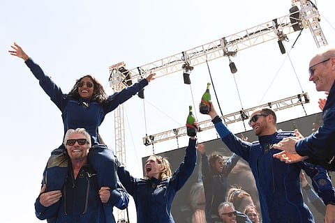 Virgin Galactic founder Sir Richard Branson (L), with Sirisha Bandla on his shoulders, cheers with crew members after flying into space aboard a Virgin Galactic vessel (AFP)