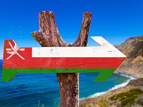 Oman flag sign with coast background.