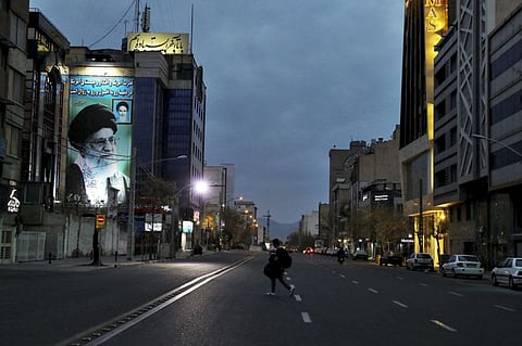 A pedestrian crosses an empty street in Tehran. File photo