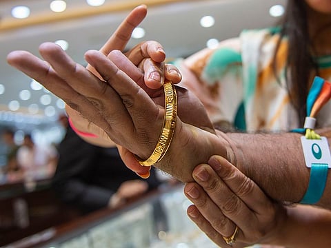 Gold jewellery on display at a Dubai souk as prices edged slightly higher in early trade, while rates in India fell sharply, offering relief to buyers.