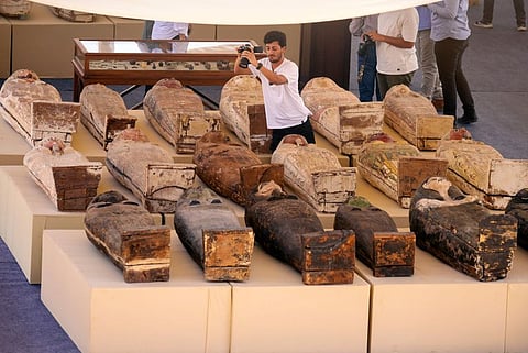 A reporter films painted coffins with well-preserved mummies inside,  at a makeshift exhibit at the feet of the Step Pyramid of Djoser in Saqqara, 24km southwest of Cairo, Egypt. Picture for illustrative purposes.