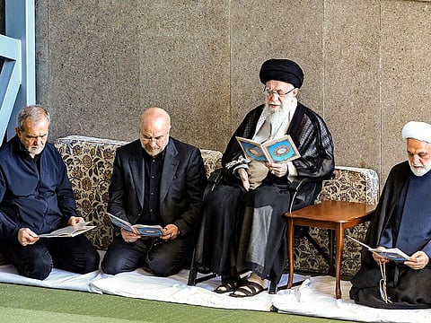 A handout picture provided by the office of Iran's Supreme Leader Ayatollah Ali Khamenei on October 4, 2024, shows him (C), Iran's President Masoud Pezeshkian (L) and Judiciary Chief Mohsen Ejeie (R), reading the Koran during the Friday noon prayer at a mosque in Tehran.