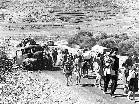 A group of Arab refugees walks along a road from Jerusalem to Lebanon, carrying their belongings with them on Nov. 9, 1948. The group was driven from their homes by attacks in Galilee. For the first time, the United Nations will officially commemorate the flight of hundreds of thousands of Palestinians from what is now Israel on the 76th anniversary of their exodus, an action stemming from the UN's partition of British-ruled Palestine into separate Jewish and Arab states.