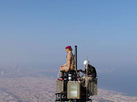 A custom platform with an attached pole was built at the top of Burj Khalifa for Nicole. She was attached to the pole as well as two other different points directly to the pinnacle, through a hidden harness under the Emirates uniform.