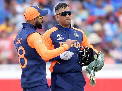 India's captain Virat Kohli ((L) speaks with Mahendra Singh Dhoni during the match against England at Edgbaston in Birmingham.