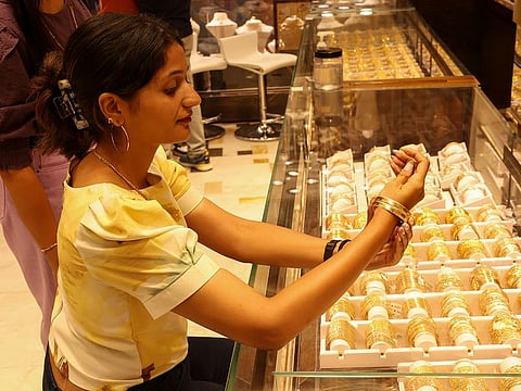 An Indian woman trying out gold bangles at a local store in the UAE. This image is for illustrative purposes only