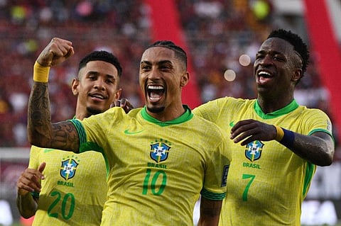 Raphinha celebrates with teammates Savinho and Vinicius Jr