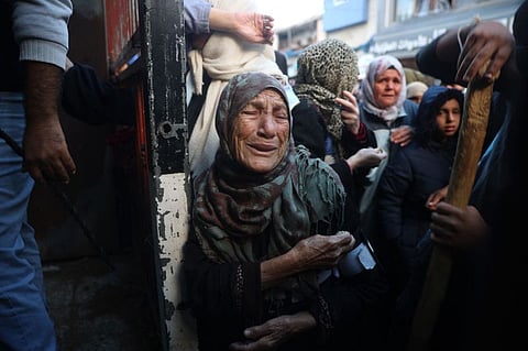 Palestinians wait for bread outside a bakery in the Nuseirat camp in central Gaza on November 27, 2024, amid the ongoing war in the Palestinian territory between Israel and Hamas. (Photo by Eyad BABA / AFP)