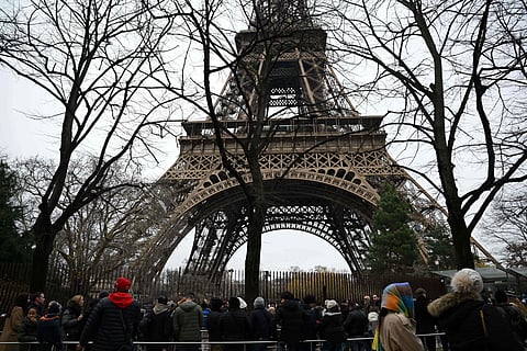 Visitors queue at the bottom of the Eiffel Tower as the site was closed and then reopened after a fire was reported in Paris, on December 24, 2024.
