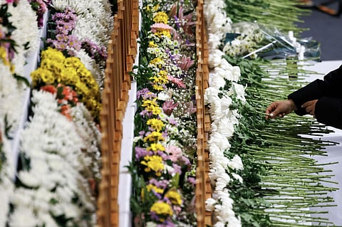 A mourner lays a flower at a memorial for the victims of the Jeju Air Co. Flight 2216 crash in Muan County, South Korea, on Monday, Dec. 30, 2024.