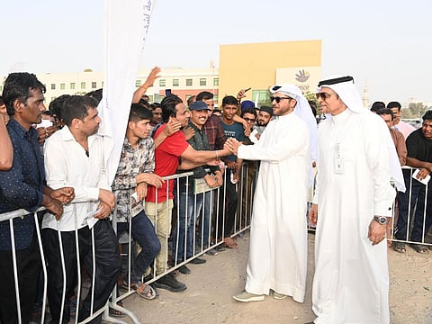 File photo of an interaction between workers and Major General Obaid Muhair bin Suroor (2nd R), who chairs the Permanent Committee for Labour Affairs in Dubai