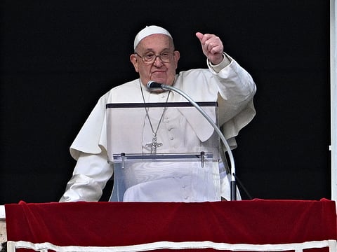 Pope Francis gestures to the crowd from the window of the Apostolic Palace overlooking St Peter's Square during the Epiphany Angelus prayer, in the Vatican, on January 6, 2025.