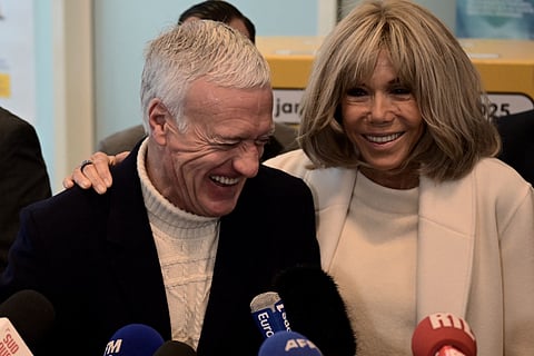 French national football team's head coach Didier Deschamps (left) and French President's wife Brigitte Macron share a laugh as they address journalists' outside Bordeaux's main post office on Wednesday.