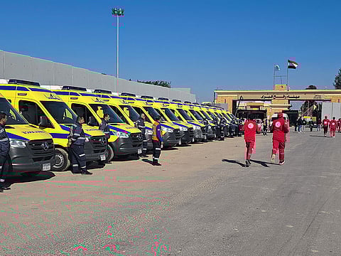 Paramedics and ambulances wait on the Egyptian side of the Rafah border crossing with the Gaza Strip on January 18, 2025, to enter into Gaza following the Israeli cabinet's approval of a ceasefire deal amid the ongoing war between Israel and Hamas.