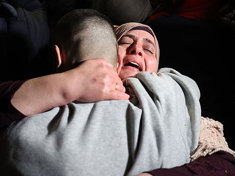 A Palestinian woman embraces her freed son upon his arrival among some 90 prisoners set free by Israel in the early hours of January 20, 2025, in the occupied West Bank town of Beitunia, on the outskirts of Ramallah.